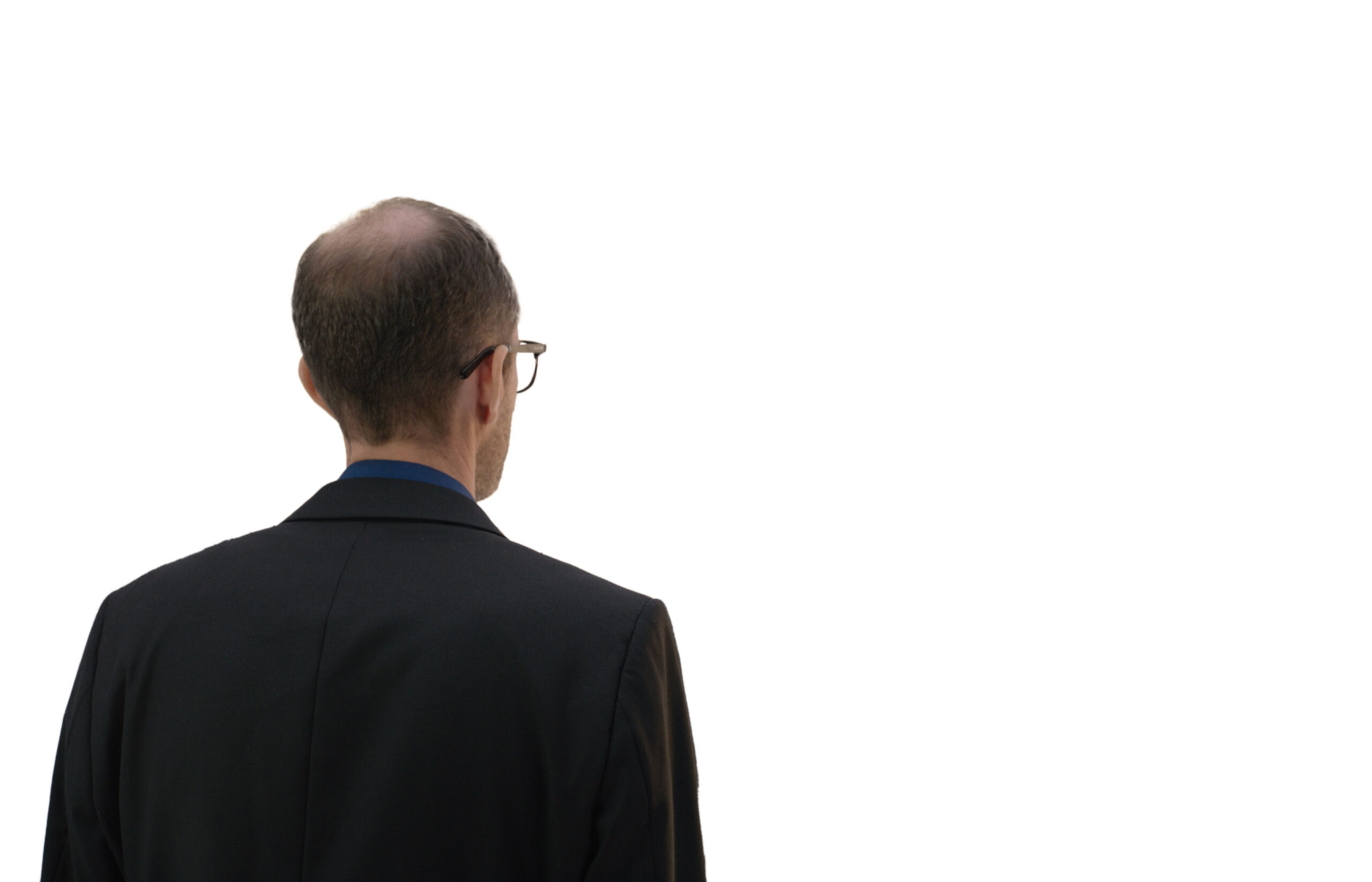 Ein Mann in Anzug und Krawatte steht vor einem weißen Hintergrund.